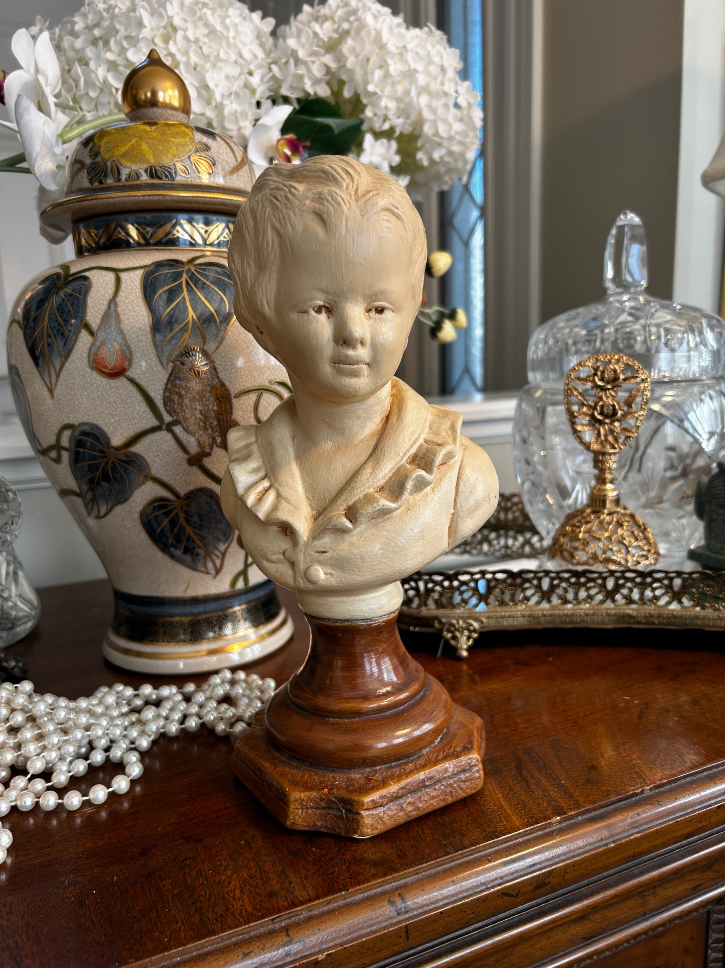 Lovely vintage statue bust of young boy in a puffy shirt in antique ivory .