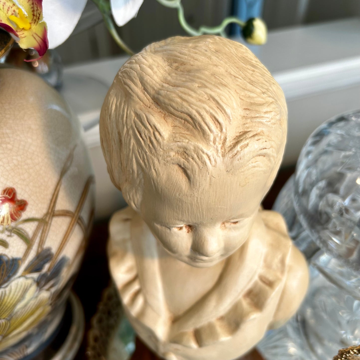 Lovely vintage statue bust of young boy in a puffy shirt in antique ivory .