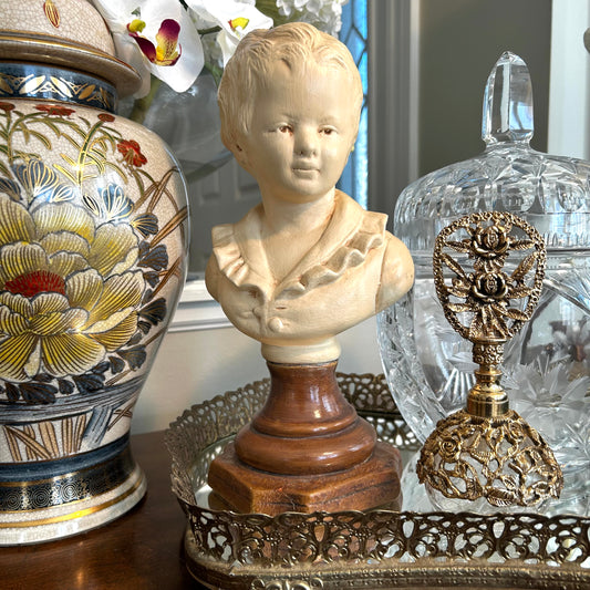 Lovely vintage statue bust of young boy in a puffy shirt in antique ivory .